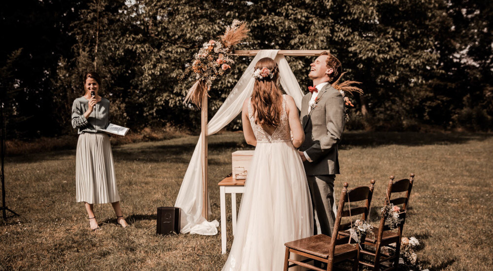 Foto Nadine Liffers 2021, Wasserburg Geretzhoven Bergheim Traurednerin Verena und lachendes Brautpaar beim JA-Wort